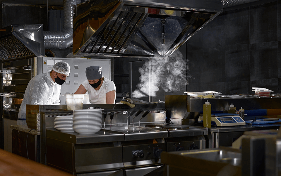 Ficha Técnica Chefs preparando ficha técnica em uma cozinha de restaurante corporativo
