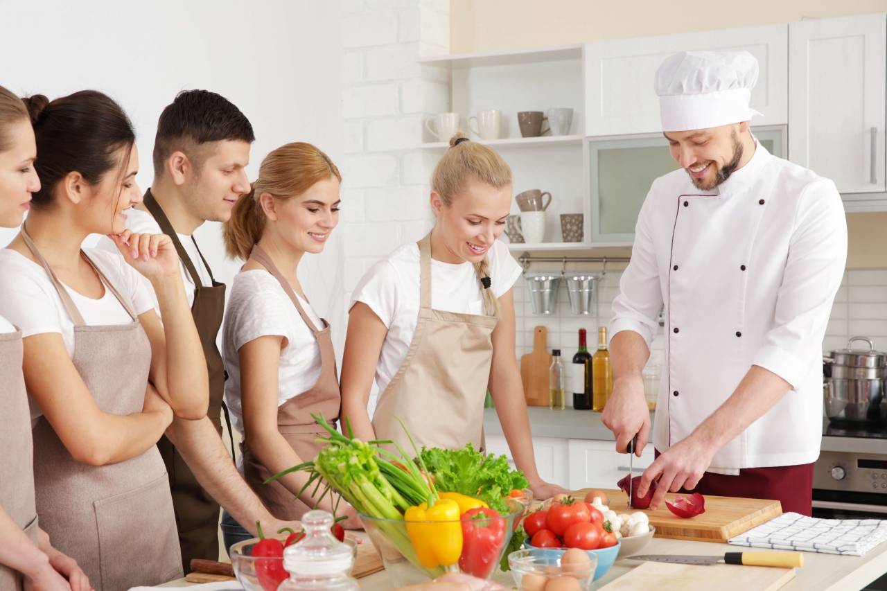 Falhas no receituário Chef demonstrando como preparar um prato para alunos em uma cozinha